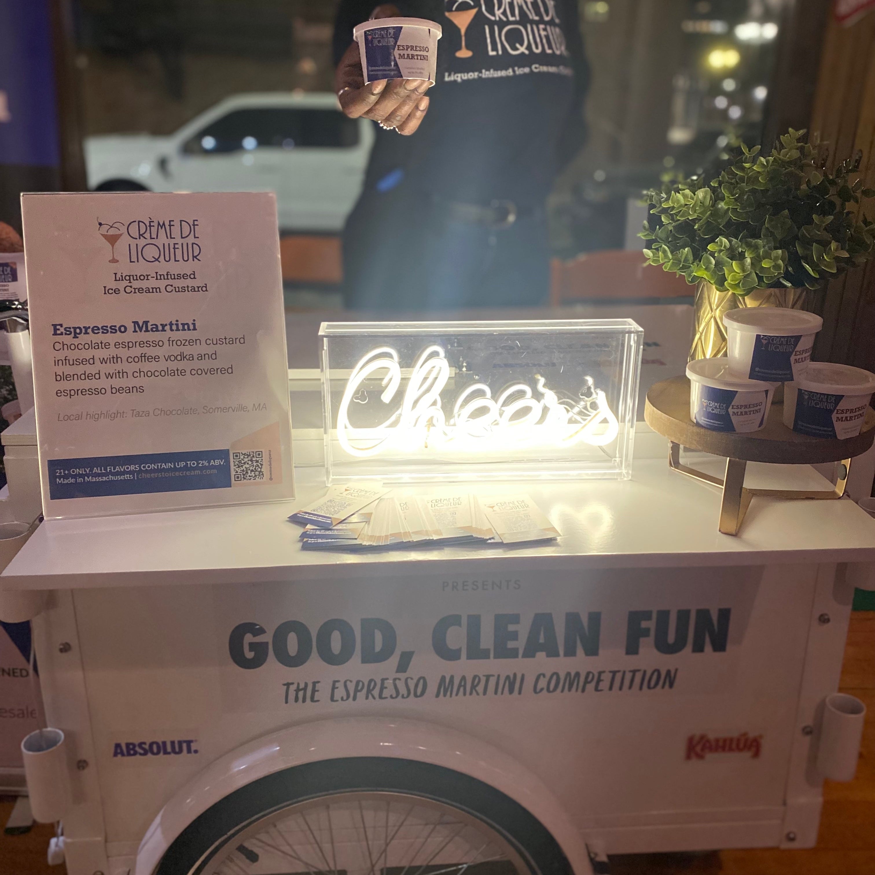 White ice cream cart with 'Good, Clean Fun' text, featuring a neon cheers sign and espresso martini ice cream from Crème de Liqueur