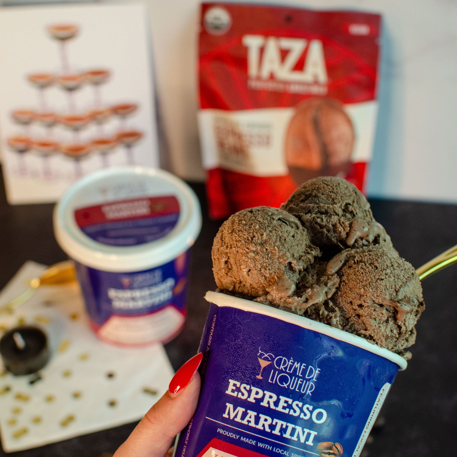 Hand holding a pint of Espresso Martini frozen custard with Taza Chocolate covered espresso beans in the background